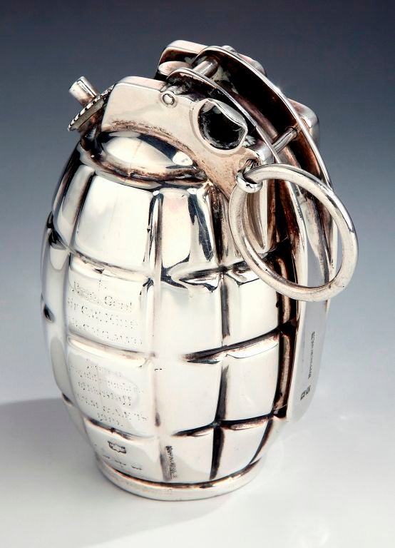 An extremely rare 1918 Sterling silver table cigar lighter realistically modelled in the form of a No. 5 Mills grenade, complete with detachable ring, folding clip etc, with rubbed engraving reading “To Brig. Gen Sir C. W. King, KCMG, MVO, from old
