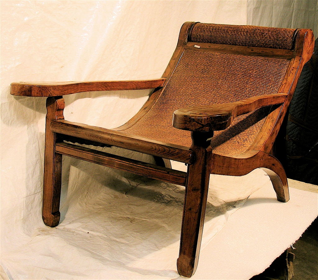 A Plantation Lounge Chair from Southern China. Elm wood frame with finely woven rattan support and rotating headrest. Excellent condition.