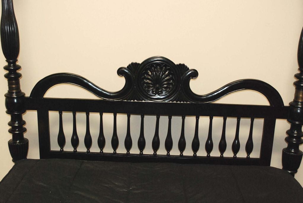 A British colonial bed in queen-size, headboard with shell motif above turned and tapered spindles, four turned posts with brass hardware above fluted tassels on feet. Finials raise to allow for optional canopy.

Measures: Queen: $8,900.00, 65.6 W