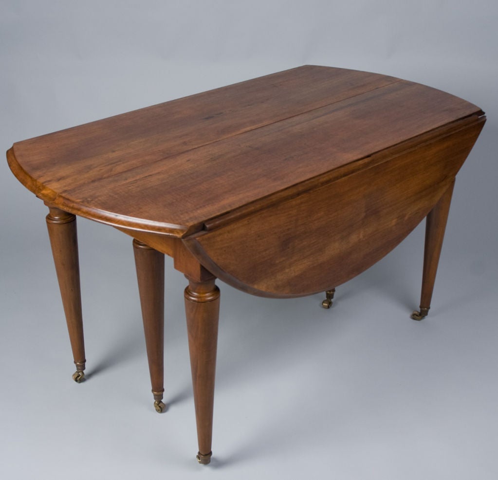 This Louis XVI Dining Table is made of walnut with brass casters on the 6 tapered legs. The Table is round (53.5