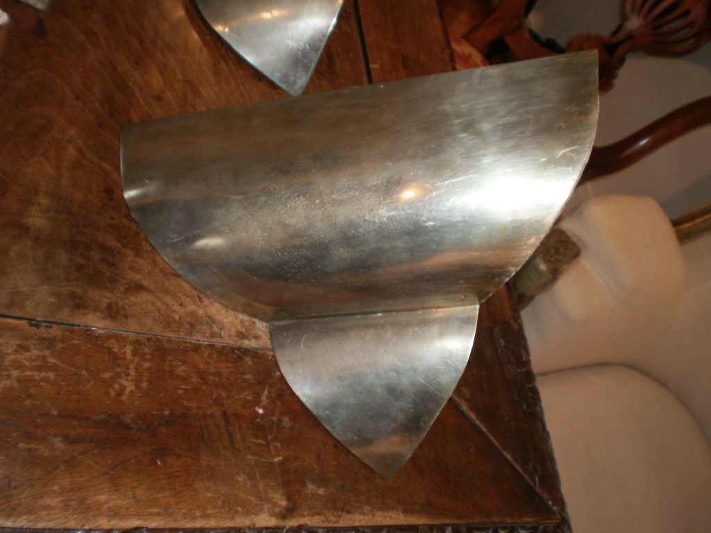 Bel ensemble de quatre appliques d'époque Art Déco en acier nickelé. Ces appliques déco françaises sont faites pour être utilisées dans les coins et sont nouvellement câblées pour le marché américain. Ils peuvent être modifiés pour être utilisés sur