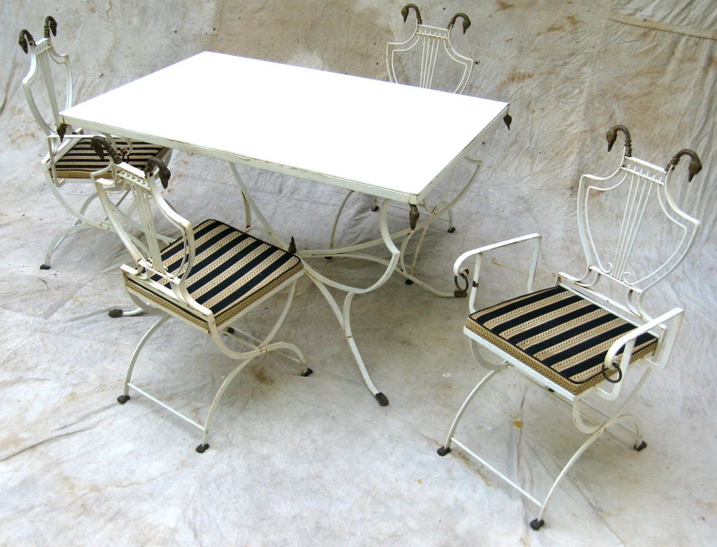 White painted Regency style table with original white glass top and four lyre back chairs (two arm and two side) with Swan heads and Lion paw feet the measurement is for table