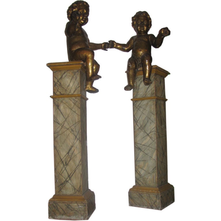 Pair of 18th c. Italian carved gilt-wood Putti figures on later faux marble painted pedestals.

After 43 years of business we are retiring. Everything must be sold. Many of the pieces listed here on 1stdibs represent markdowns below our cost.