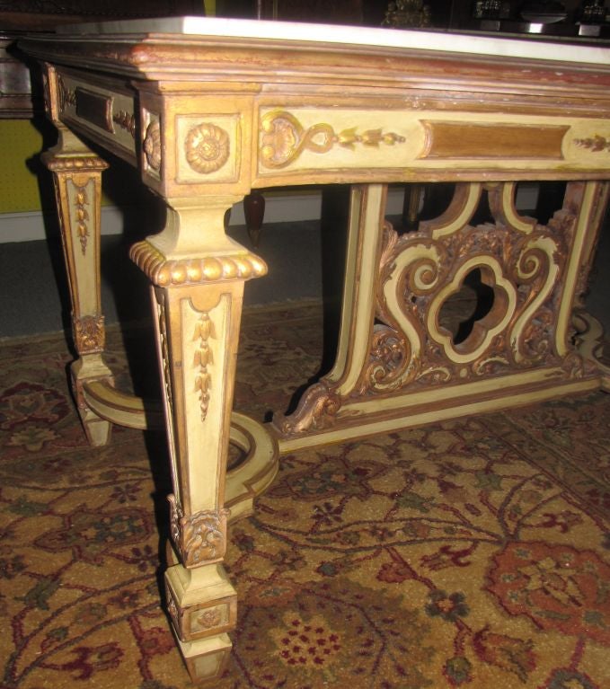 Italian carved painted and parcel gilt marble-top center table with h-form stretcher support.