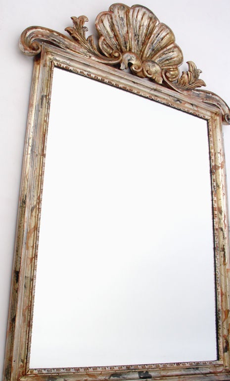 Elegant Hand Carved Wooden Mirror with Silver and Gold Gilt Finish, executed by LaBarge, circa 1960's. It has a wonderful patina that only comes with age, and the original distressed gilt finish is mainly silver gilt, with gold gilt, chinese red and
