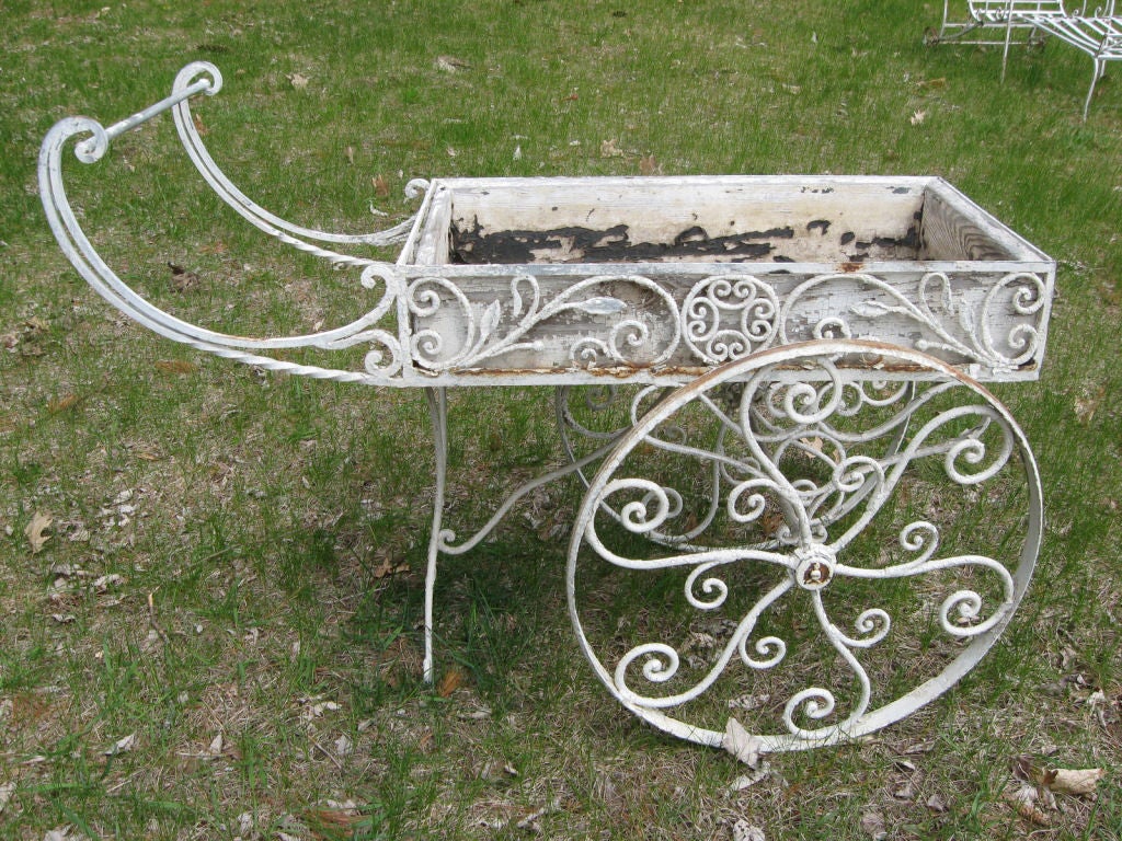 painted white,iron flower cart having graceful scroll and leaf design. attributed to 