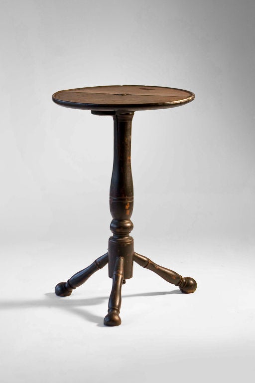 Candlestand with circular top, turned pedestal, three turned legs and ball feet. Black paint is not original.