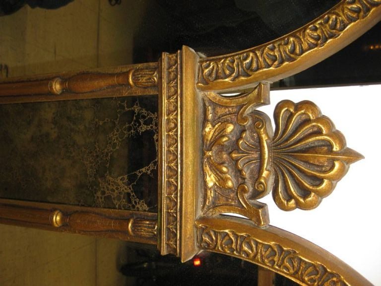 Large five panel Hollywood Regency mirror, with three églomisé minaret columns, and two solid mirror panels, this mirror has motif and influences from India in addition to egg and dart molding from 3rd century Greek architecture, please also visit