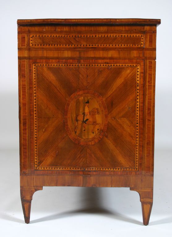A late 18th century northern Italian neoclassical style marquetry inlaid commode; the rectangular top above three drawers, the lower two centered with a marquetry oval and having round neoclassical style handles; the sides similarly decorated; the