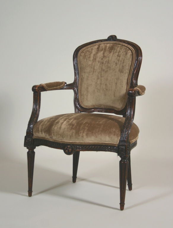 An Italian late 18th century transitional period armchair;

the carved cartouche shaped back above a serpentine seat and acanthus carved arms to a vitruvian scroll carved seat rail, raised on fluted legs.