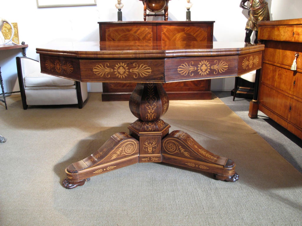 Important Charles X period rosewood 12 sided center table intricately inlaid with neoclassical boxwood designs all resting on tripod pedestal ending in lion paw feet. The frieze fitted with six drawers.