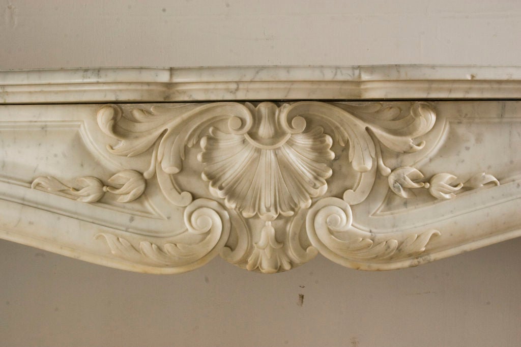 Régence style white carrara marble fireplace mantle - finely carved with shells, bellflowers ancanthus leaves and scrolls.