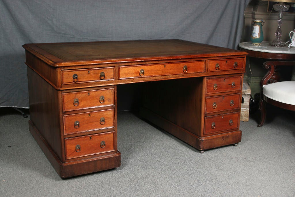 English mid-19th century mahogany pedestal desk; the top inset with tooled leather writing surface, one side fitted with drawers the other fitted with cabinet doors.
