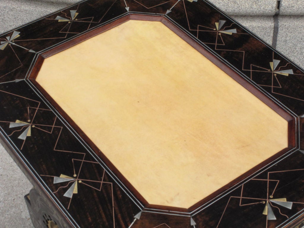 Walnut octagonal center table by Carlo Bugatti (1856-1940), inlaid with pewter, brass and bone, upholstered with parchment.<br />
<br />
Rare and important suite of five pieces of furniture by Carlo Bugatti comprising a writing desk, a center