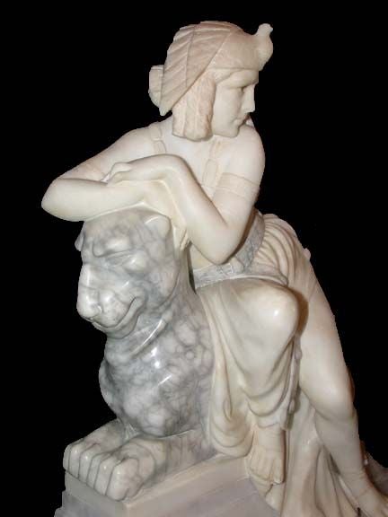 Figural group of fabled Una, wearing peacock headdress, halter, and draped skirt, reclining on a lion ,sculpted in various marbles on stepped alabaster plinth. Interior light to alabaster plinth.