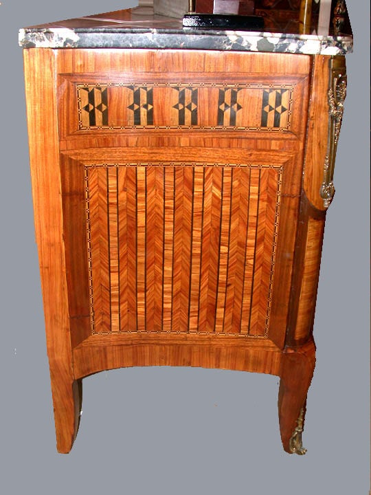 Transition Louis XV-XVI style kingwood and marquetry serpentine front three-drawer commode with conforming marble top. This shapely commode is perhaps more en arbalete than serpentine, with its shaped curved sides it has a lightness of being that