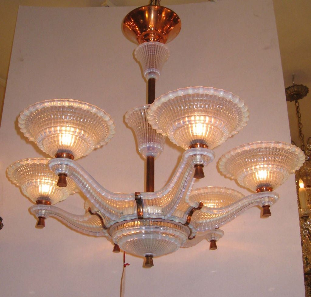  This very unusual Art Deco six-arm and eight-light opalescent glass ceiling fixture is on a copper-banded and glass stem. Each glass  pan on outstretched arm is finished with a copper tassel and shank and is signed Ezan; the central bowl is