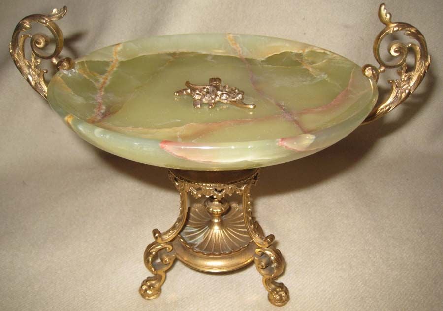 Napoleon 111 gilt bronze tazza, the volute  handles holding the onyx dish with bow, arrow, and wreath central decoration, over curved tripod legs joined by double urn form columns.