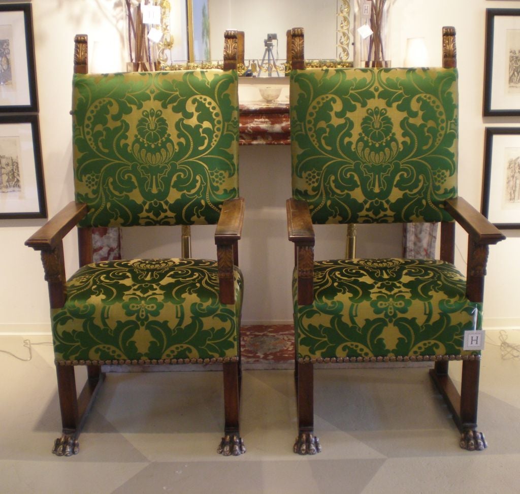 Large Pair of Renaissance Revival Carved Walnut Arm Chairs, <br />
upholstered in green amazing damask,<br />
having paw-footed legs and gilt acanthus finials