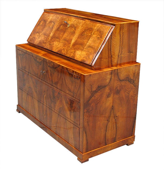A practical Biedermeier writing desk with a lower 3 drawer chest for storage and an upper lectern part for writing with fall front and fitted interior. Walnut on pine in perfect matching pattern. Inlaid with maple. Original locks including one with