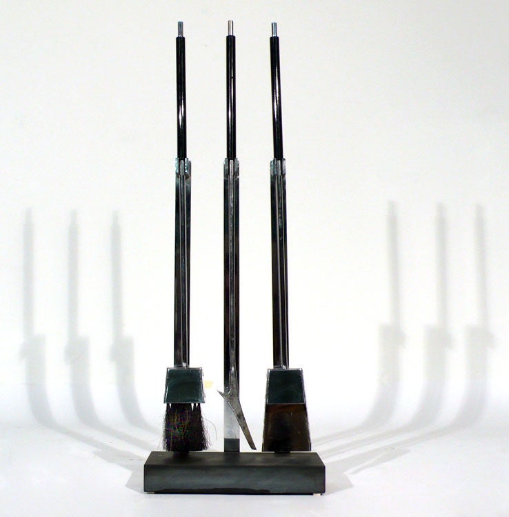 1970s Italian chrome-plated fireplace tools. The black slate base and flat bar steel supports are ultramodern in design and would work well with any upscale interior.