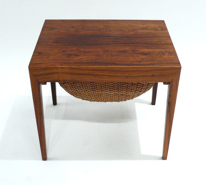 Exquisitely crafted gorgeous rosewood side table with removeable woven sewing basket and hidden compartmentalized drawer designed by Severin Hansen Jr. for Haslev Møbelsnedskeri. His hallmark corner joinery is what makes this piece stand out. Ultra