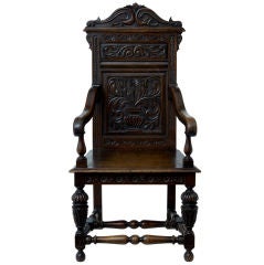 A 17th Century style carved oak wainscot armchair