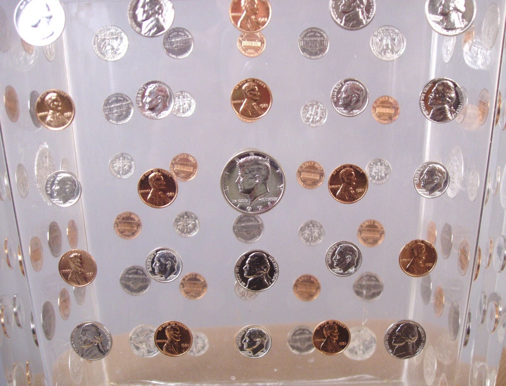 an unusual and very interesting vintage Lucite waste paper basket in lucite with coins embedded all over. mix of coins with a half dollar in the center of each side.