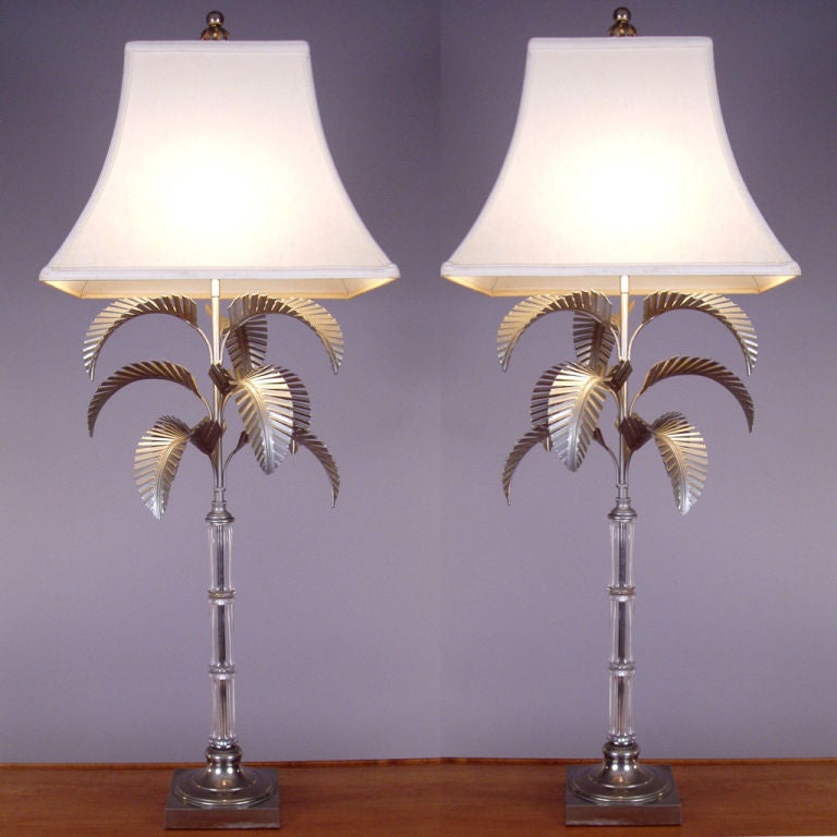 a pair of very nice vintage lamps with beautiful glass bamboo stems and steel palm leaf details, with the original matching detailed finials. great style and elegance. excellent condition. marked Chapman 1972.