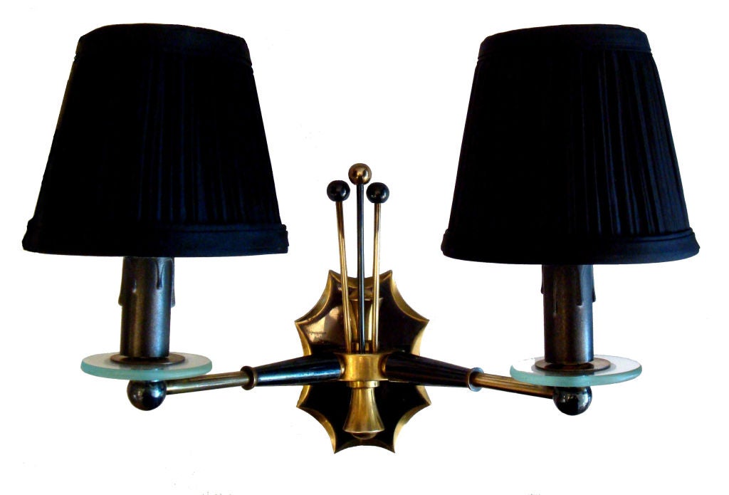 Very elegant pair of Jansen wall sconces.

Two patinas: Gun metal and brass.

Two glass disc detail at candle cup.
Back plate : 5