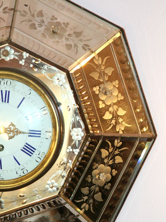 This wonderful clock is set in etched mirrored panels, forming a hexagon. It hangs from a chain.