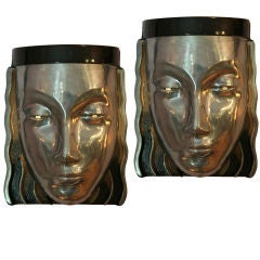 Matte chrome sconces in mask motif