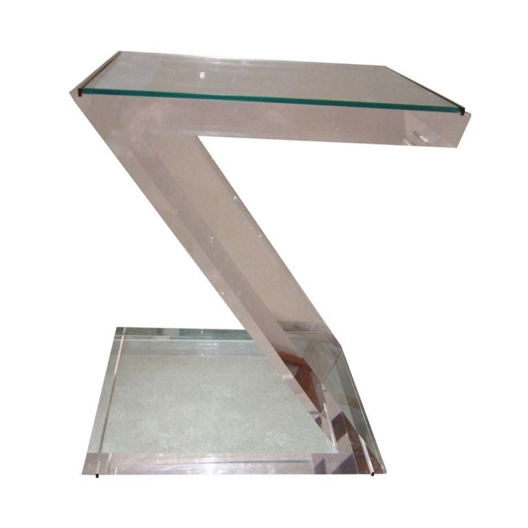 This is an outstanding example of what can be done with lucite to make it look like a sculpture. The thick lucite is all angles and asymmetrical.The top ha a glass and brass inserts.<br />
The table is designed by well known designer Jeffrey