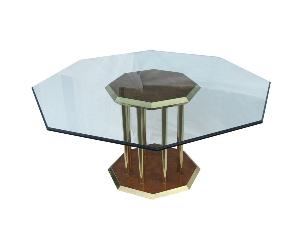 Beautiful dining table made by Mastercraft. this fabulous dining table features a gorgeous octagonal base which makes this an eye-catching piece. the base is made of burl-wood and brass with a beautiful tubular poles attaching the top and bottom of