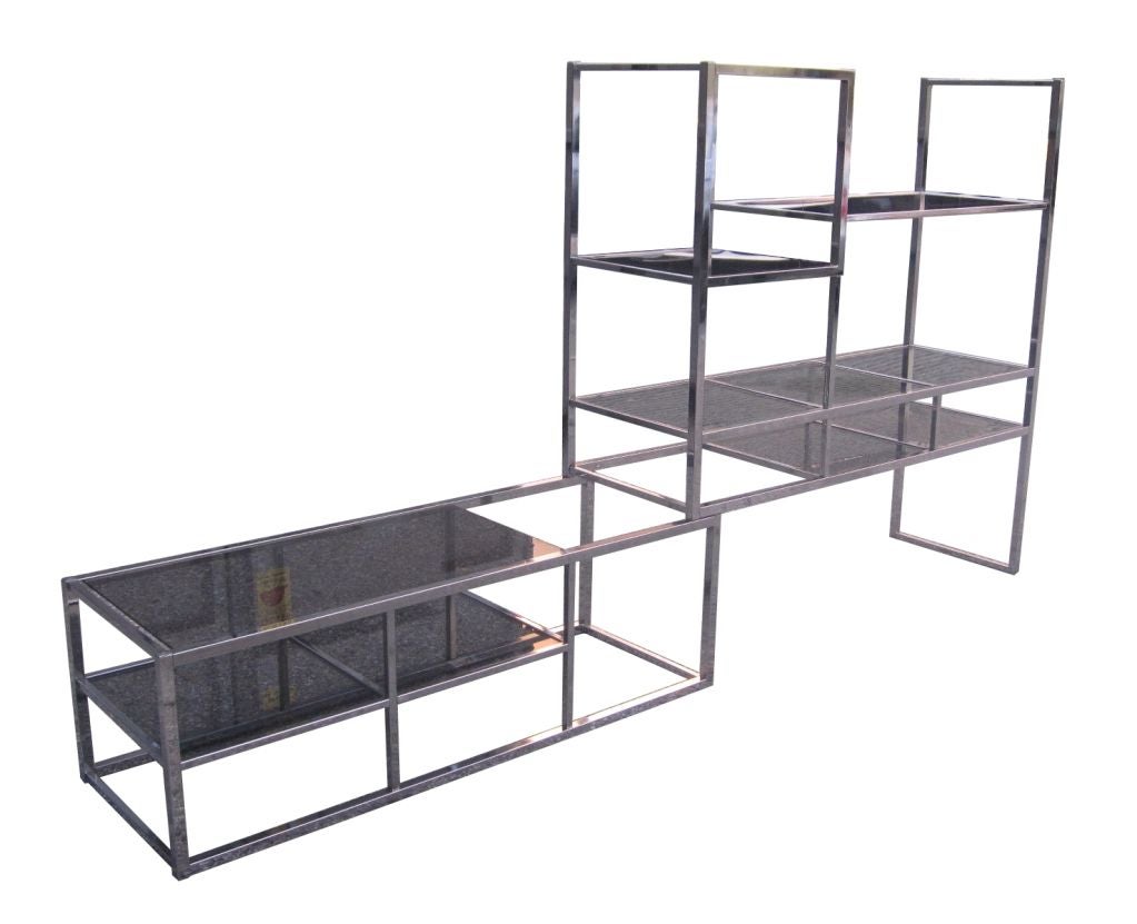 Fantastic two piece chrome etagere with expandable capabilities.

The piece was genially designed to expand and retract according to space and needs.

The chrome frame with smoked glass shelving allows for lots of room to display precious family