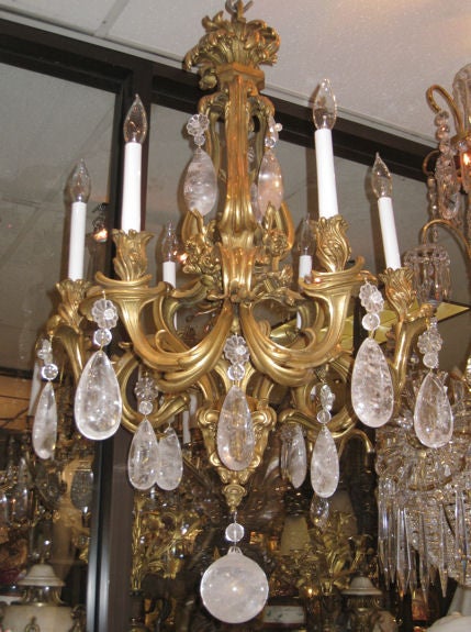 This doré bronze chandelier in the French Louis XV style features six candle arms, rock crystal pendants and sphere.
Stock number: L410.