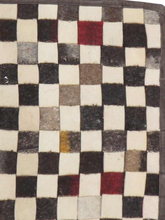 Una alfombra moderna construida con fieltro y material de tienda vintage.