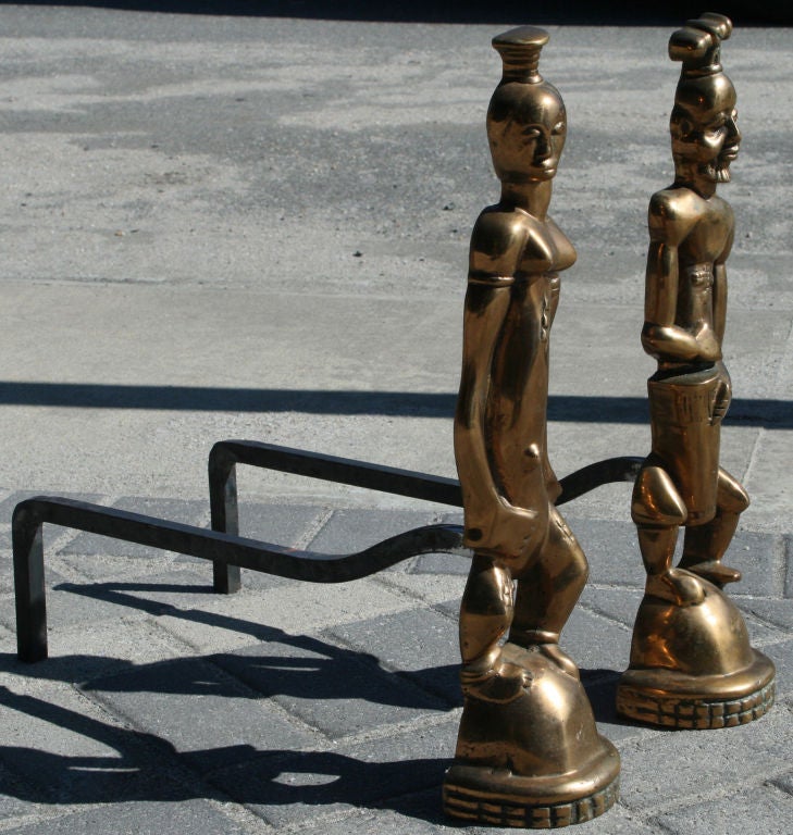 Beautiful pair of Karl Hagenauer style Nubian andirons made of cast bronze.  Showing early modernist aesthetics and stylized deco features.