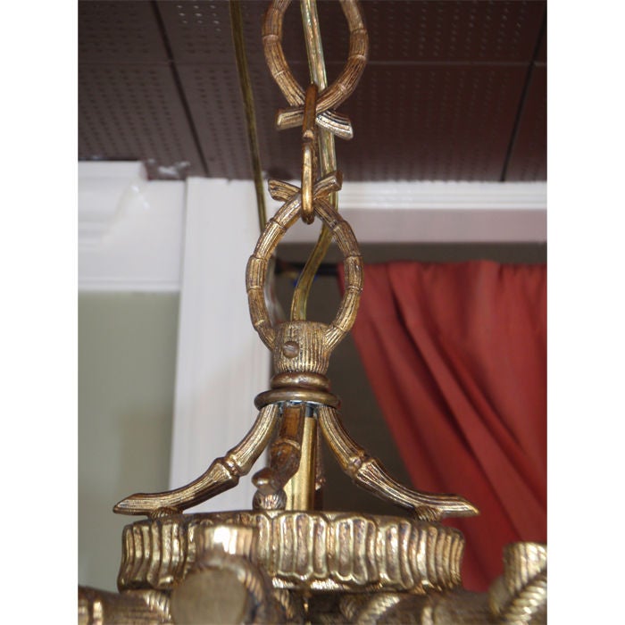 Vintage brass chandelier made to look like pieces of bamboo strapped together.  Incredibly stylish as is or topped off with pagoda shades to get that chinoiserie look.  The chain is even made to look like pieces of bamboo.