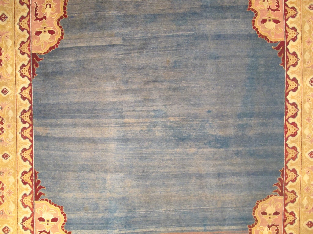Antique 19th Century Indian Agra Rug in Solid Blue Background.
This stunning antique Agra carpet beautifully illustrates the magnificent splendor of mid-19th Century Indian design and craftsmanship. The unusually bold open center field in various