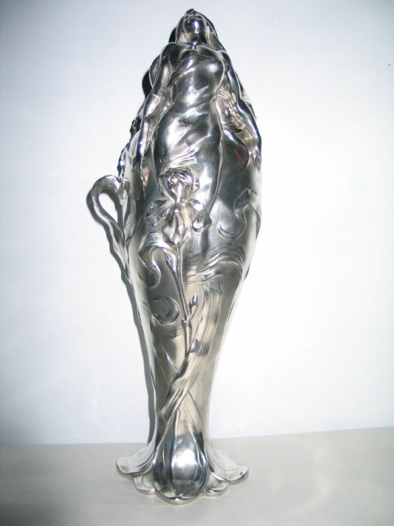 A classic Art Nouveau period style silvered pewter vase featuring a seductive partially nude female amidst wild irises in relief around the vase. It is 