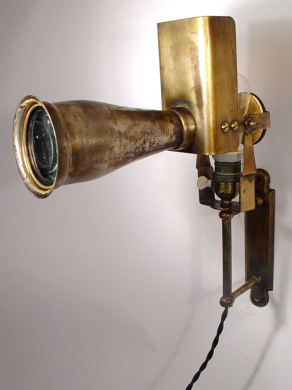 This is an early wall mounted and articulated long lens medical spot light. It's signed 