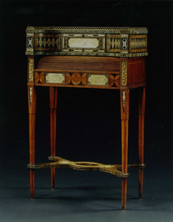 A very rare George III bonheur du jour with the incurved superstructure set with a verre églomisé mounted drawer flanked by repeating lozenge marbleized decoration. The projecting ends set with black and silver foliate verre églomisé panels. The