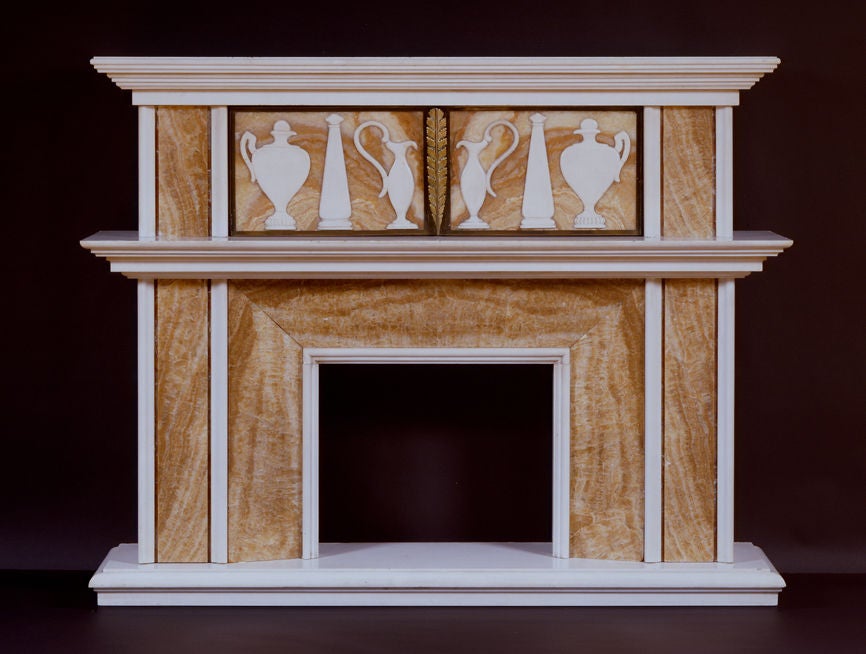 The projecting moulded statuary cornice above an Oriental alabaster frieze with applied statuary vases and obelisks in the antique taste is jet with two concealed doors with foliate ormolu handles.  The projecting moulded statuary shelf above an