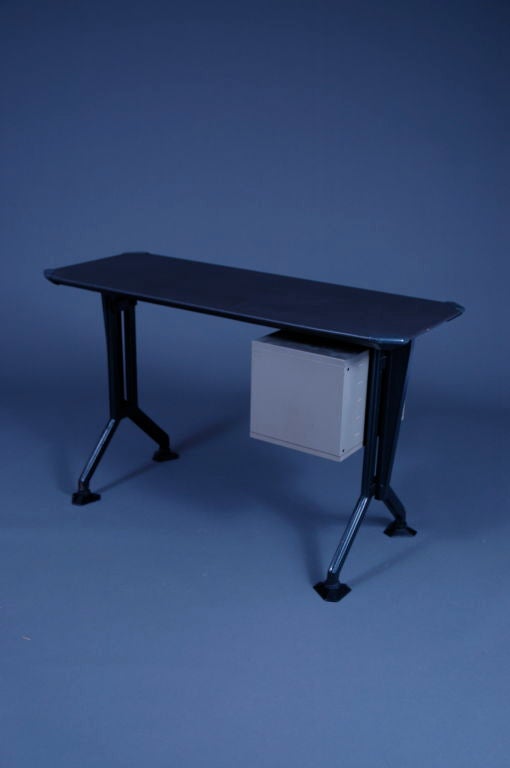 Small desk from the Arco series by studio BBPR for Olivetti. In black painted metal, top finished with a dark grey vinyl. Corners and adjustable feet in pvc.