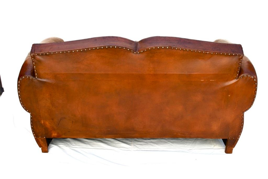 a beautiful French 1920 leather club sofa, mustache style, the patina on the leather is great, but beware because of the flash of the camera, the sofa  is little  darker, both cushions  are not original, but the matching is fantastic