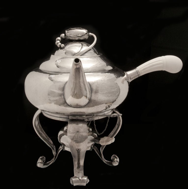 This fantastic 5 piece Georg Jensen sterling Blossom tea set sits on the 2nd largest oval tray (originally made in 6 sizes).  The set is comprising coffee pot, tea pot, tea kettle on stand with burner, and creamer, all with ivory handles, as well as
