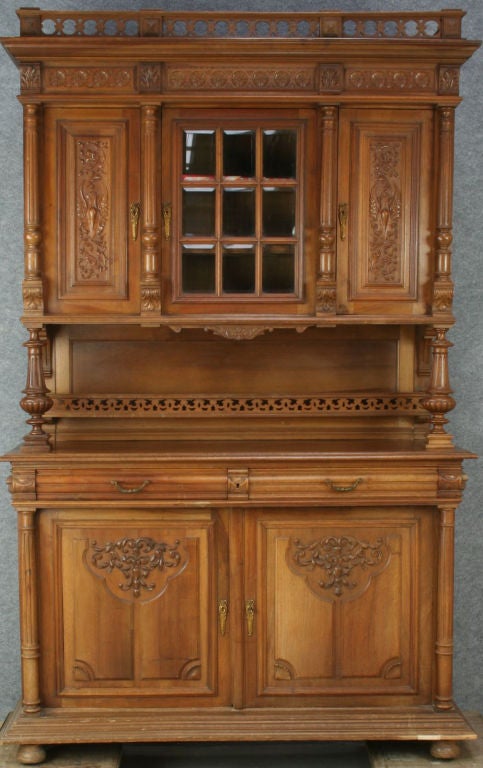 A French Henry II Renaissance Style Buffet Server Hutch in walnut with carved doors,a beveled glass center door, and a plate rack