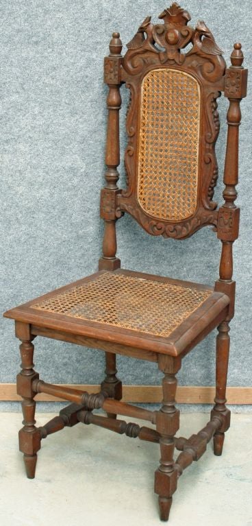 A Set of Six French Hunting style Chairs in oak with rattan backs and seats and well-carved griffins at the top