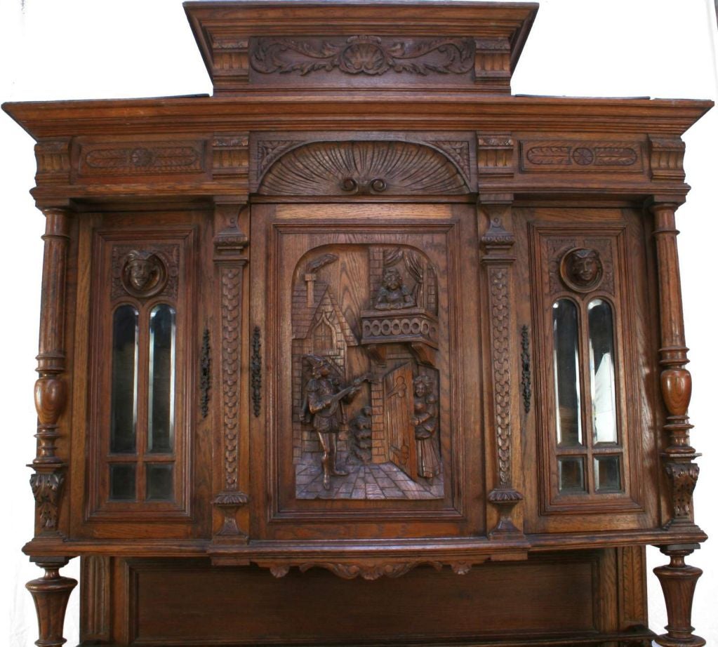 A Henry II Renaissance style Buffet Server Hutch in oak with whimsical figural carvings of a serenading troubadour and his lady